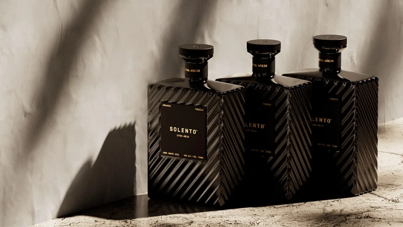 A sophisticated monochromatic bottle of Solento Organic Tequila Extra Añejo sits elegantly against a dark background, with embossed detailing and a velvet-textured finish, reflecting Studio Ethur Ethur's commitment to luxury design.